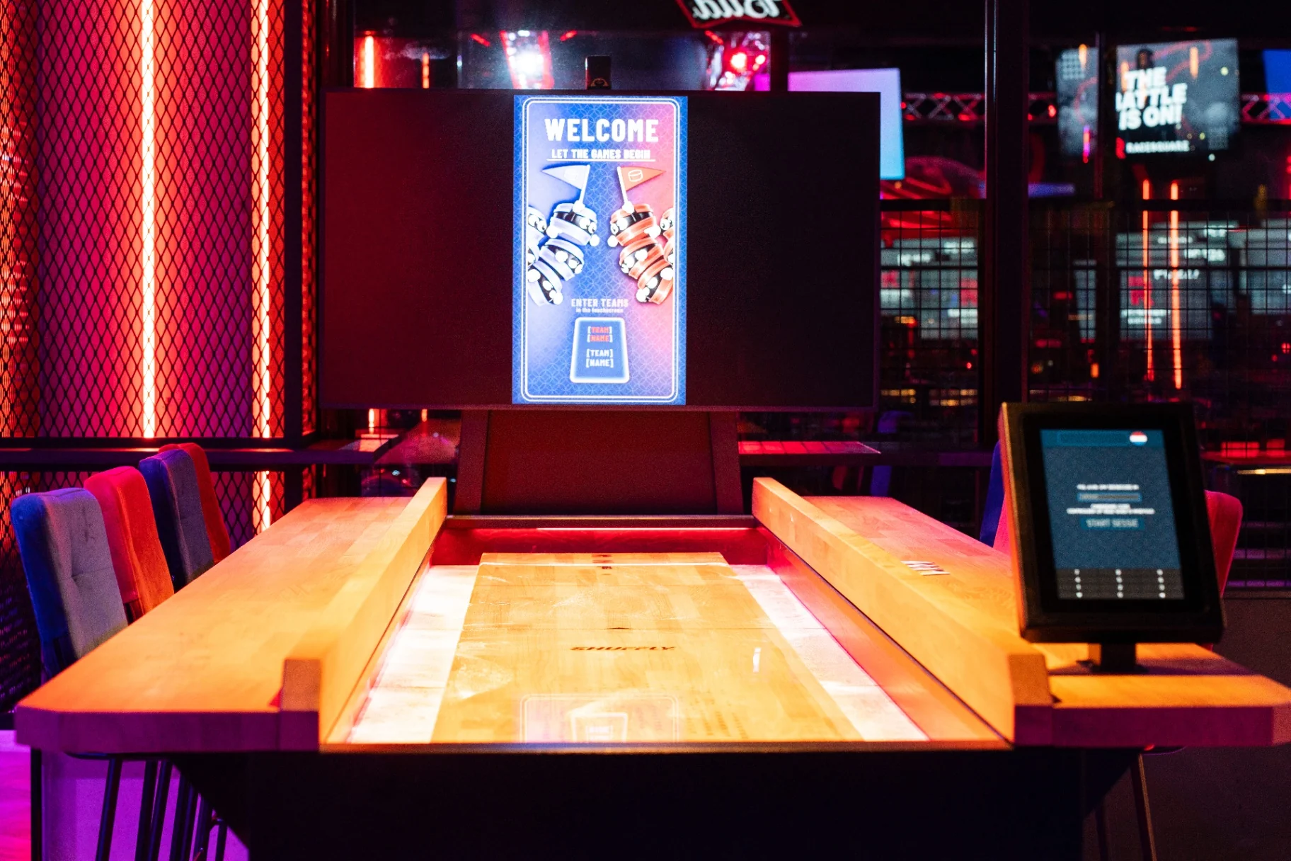 Shuffleboards at a busy leisure venue with guests around the table
