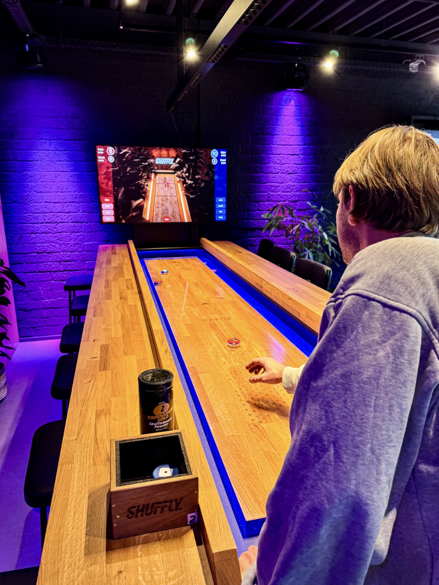 Guests playing shuffleboard on a Shuffly interactive table